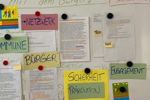 Tafel mit Zetteln und Ideen zum Thema kommunale Präventionsgremien. Stichworte sind Netzwerk, Kommune, Bürger, Sicherheit